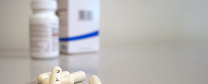 White Pills and Pill bottle with box in the background